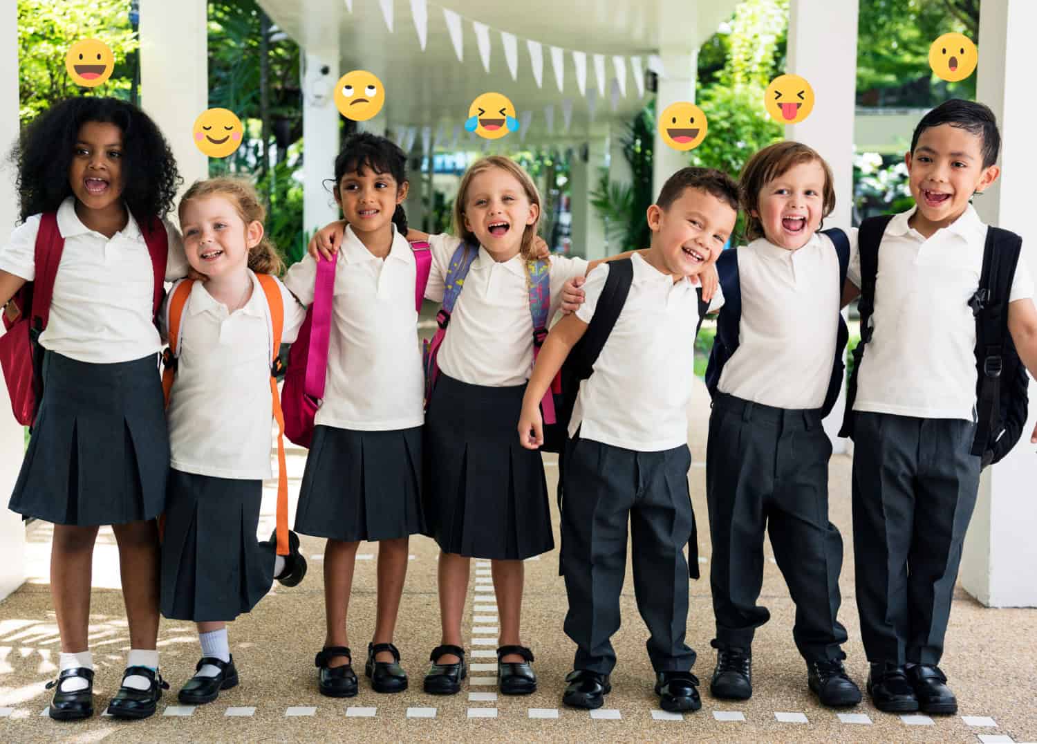 Seven children in school uniforms smile brightly, backpacks on, with emojis above—perhaps dreaming of becoming future Baton Rouge Physicians.