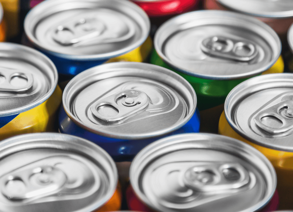 Close-up view of the tops of several unopened aluminum beverage cans, arranged closely together in rows.