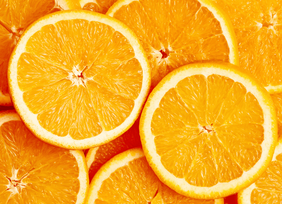 Close-up of several overlapping slices of fresh orange, showing the juicy pulp and rind in detail.